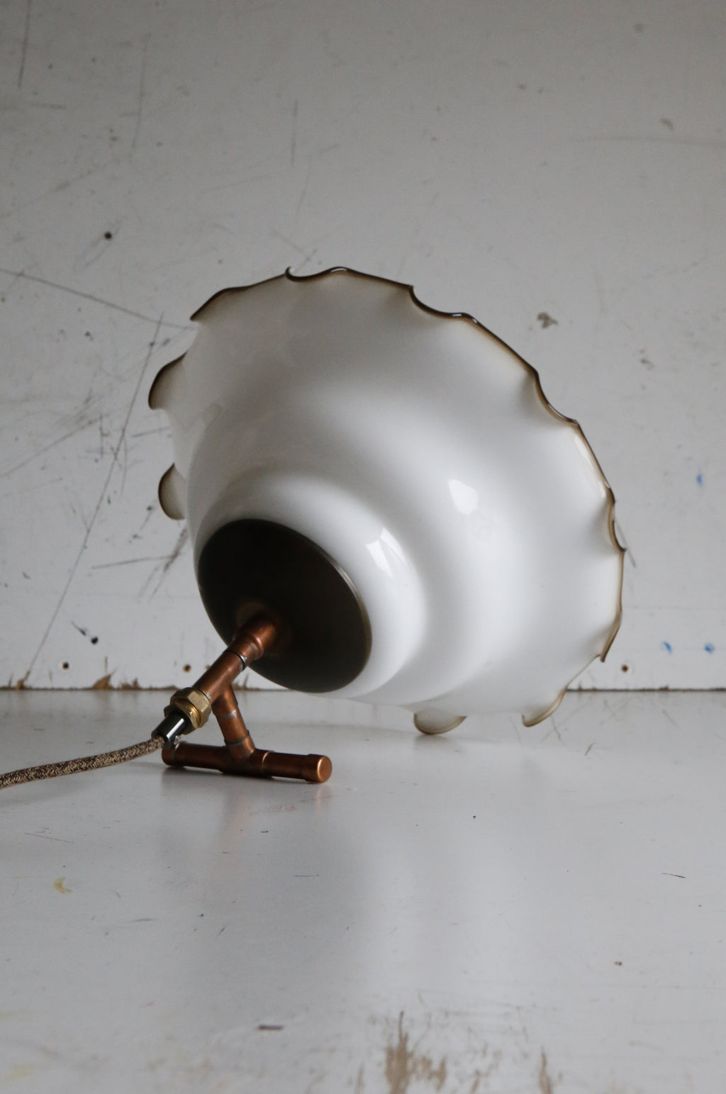 white glass shade turned into table lamp on industrial white background