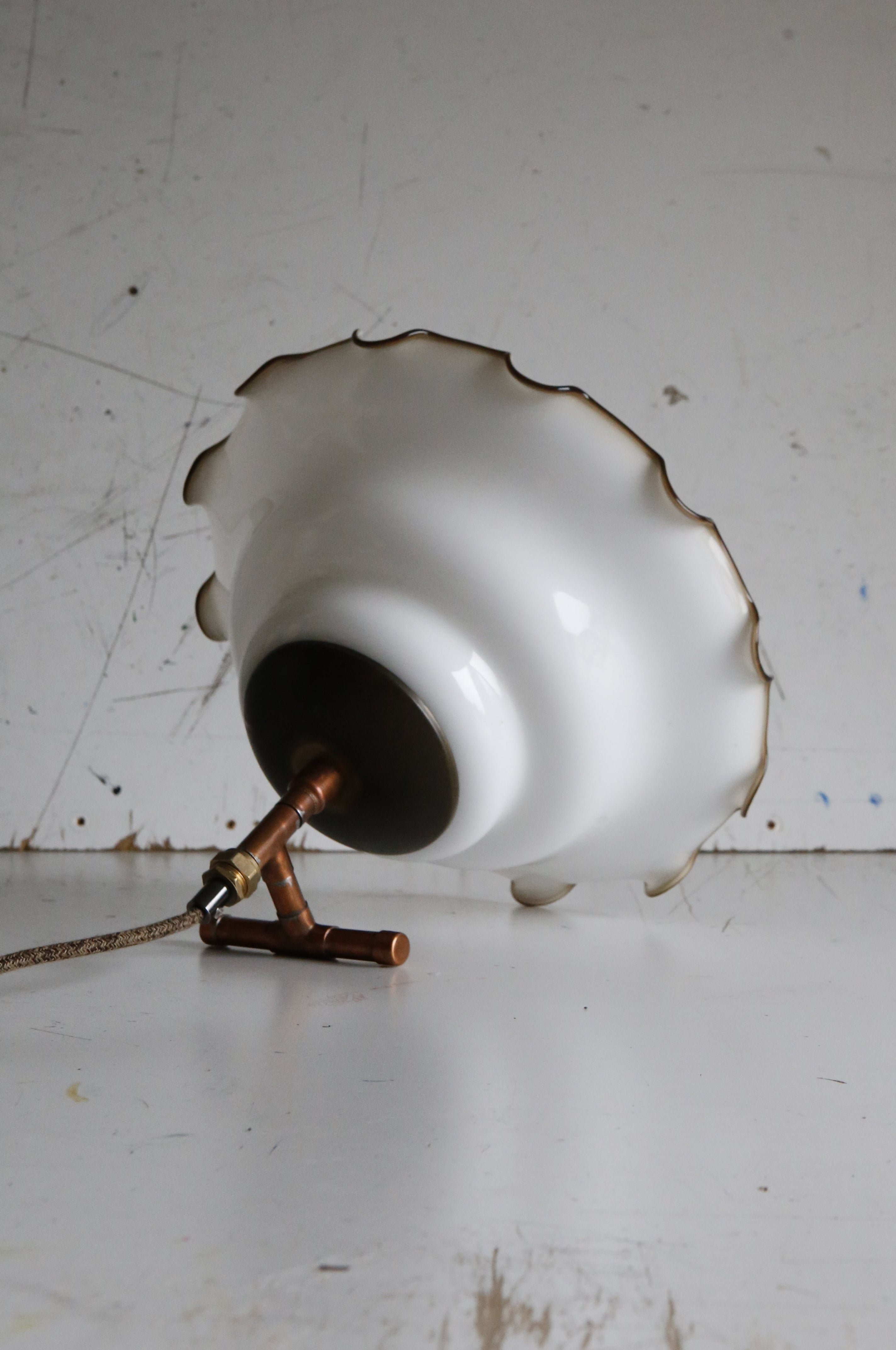 white glass shade turned into table lamp on industrial white background