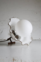 Vintage-style lamp with scalloped edge design on a white surface.