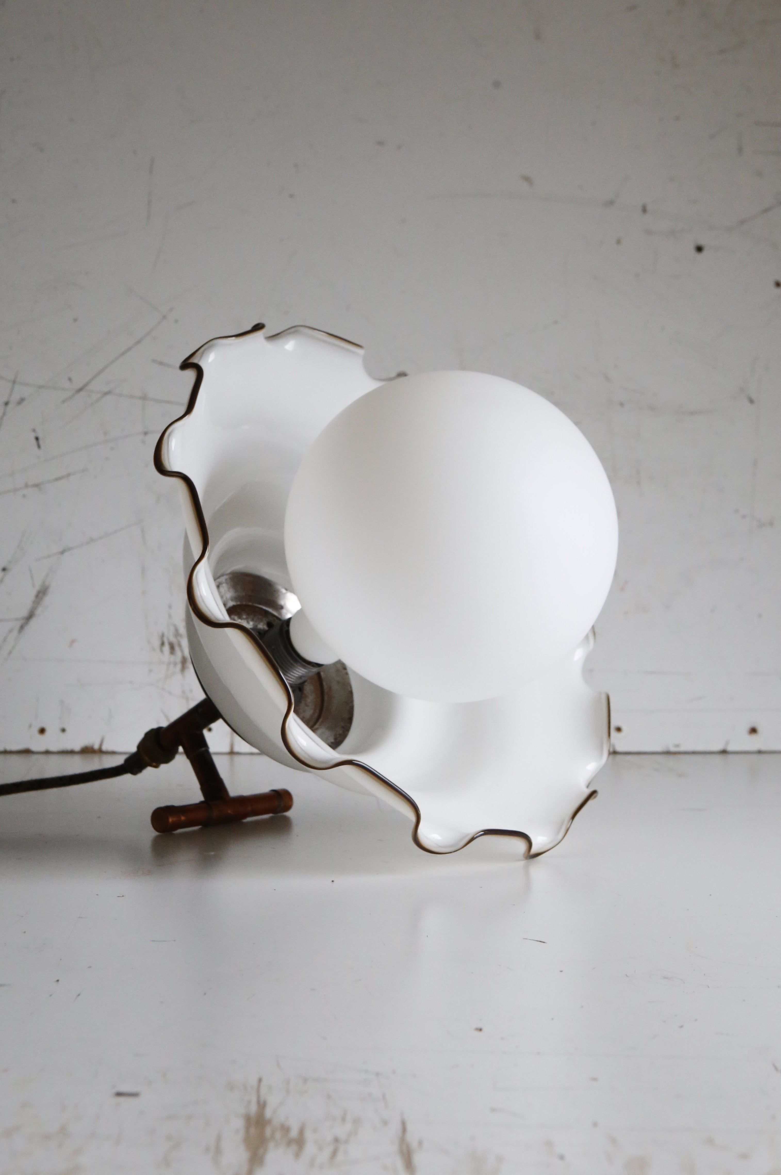 Vintage-style lamp with scalloped edge design on a white surface.