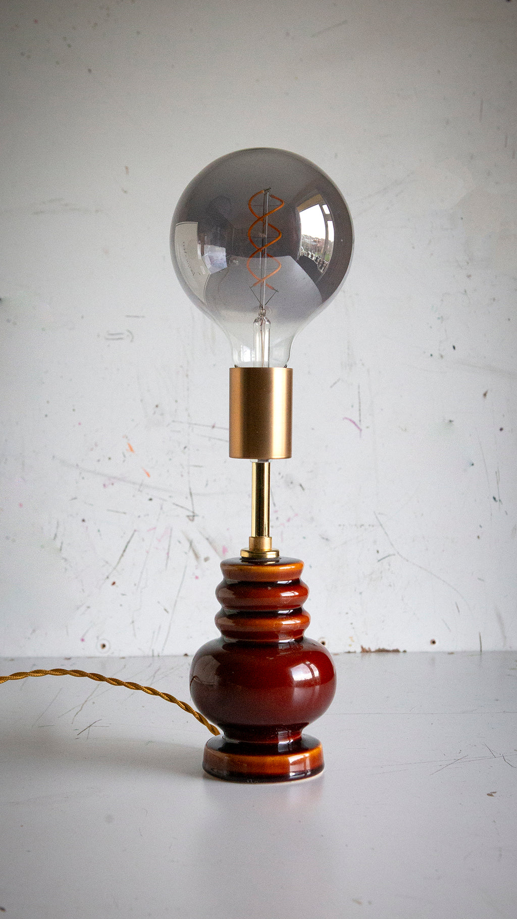 Vintage-style lamp with a large light bulb on a white surface and light gray background