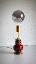 Vintage-style lamp with a large light bulb on a white surface and light gray background