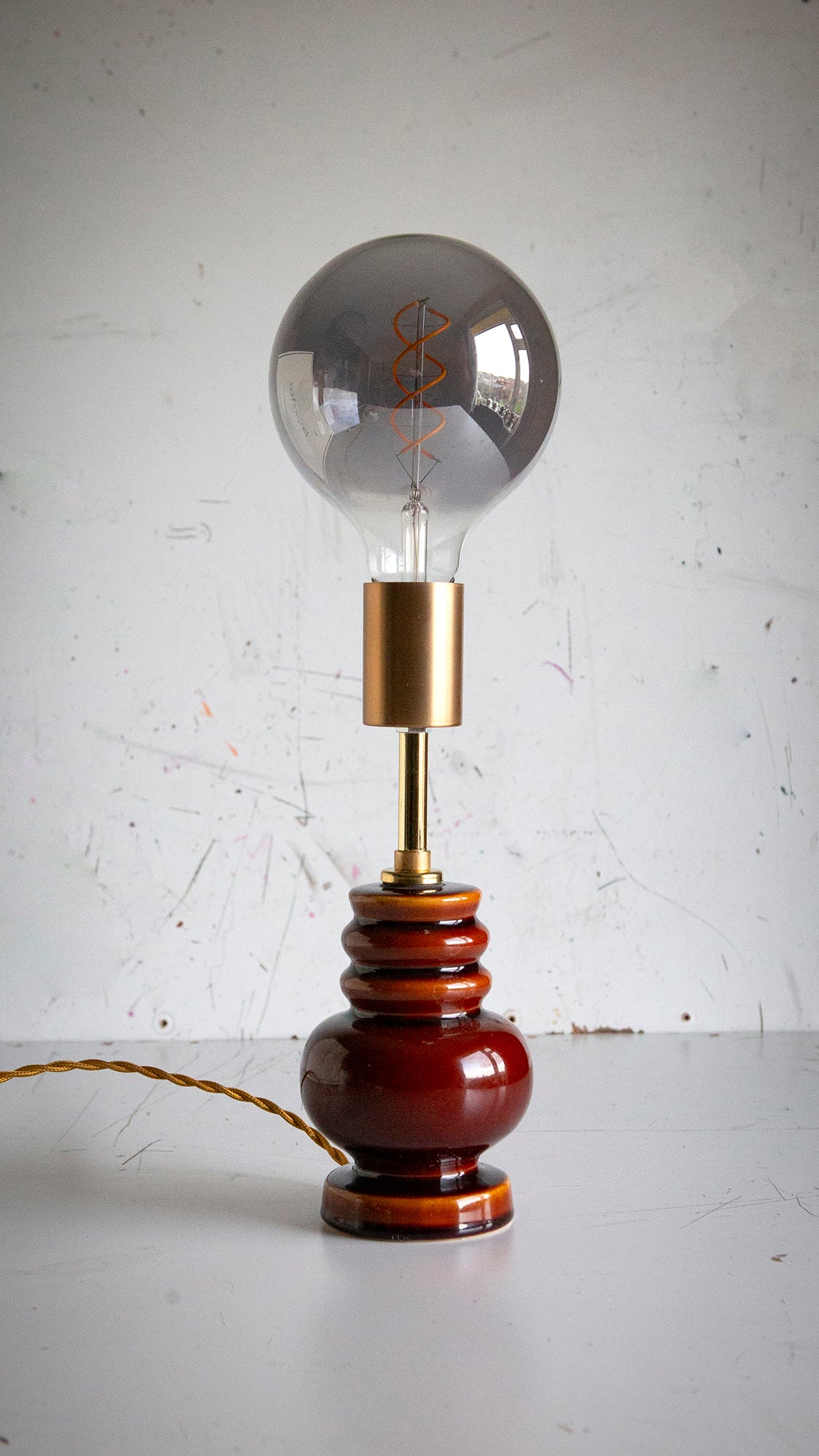 Vintage-style lamp with a large light bulb on a white surface and light gray background