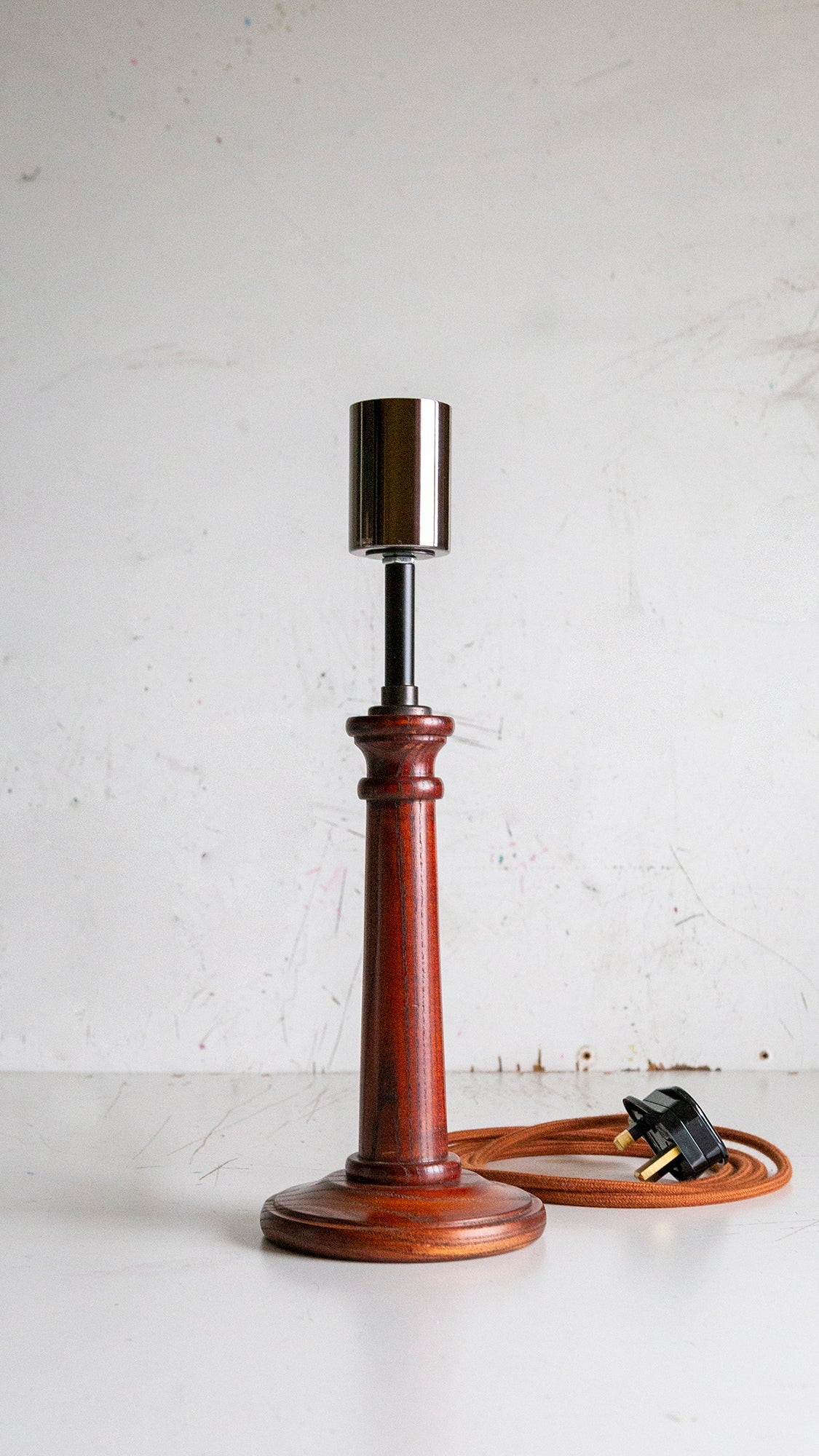 Wooden vintage table candle stick lamp with wooden base on a white surfacek