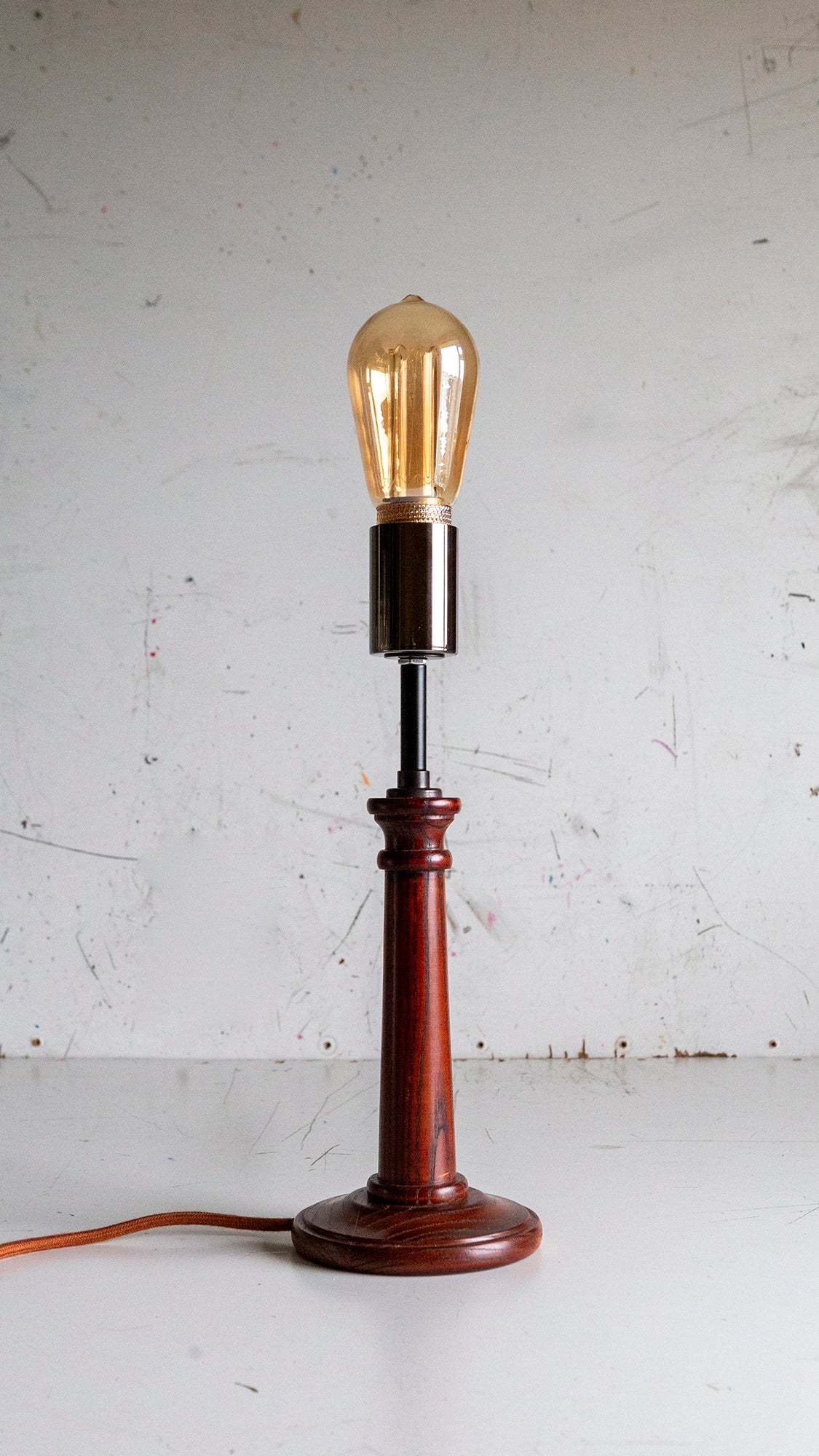 Vintage-style table lamp with a wooden base and exposed bulb on a white background