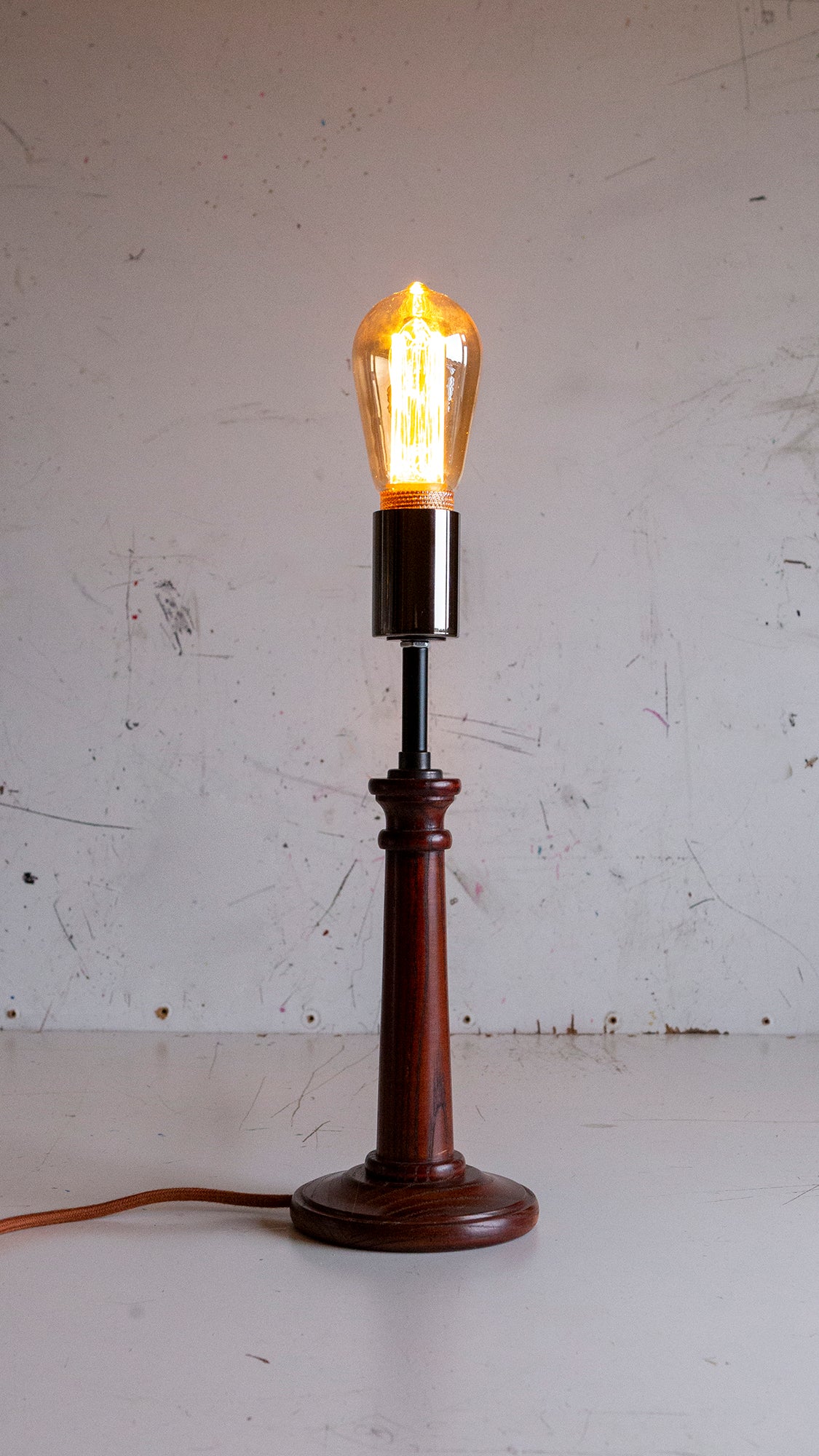 Vintage-style table lamp with a wooden base and exposed bulb on a white background