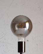 Silver or grey smokey spherical light bulb on a white background