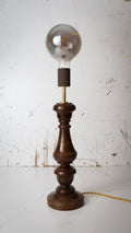 Vintage-style table lamp with wooden base and clear glass bulb on a white background