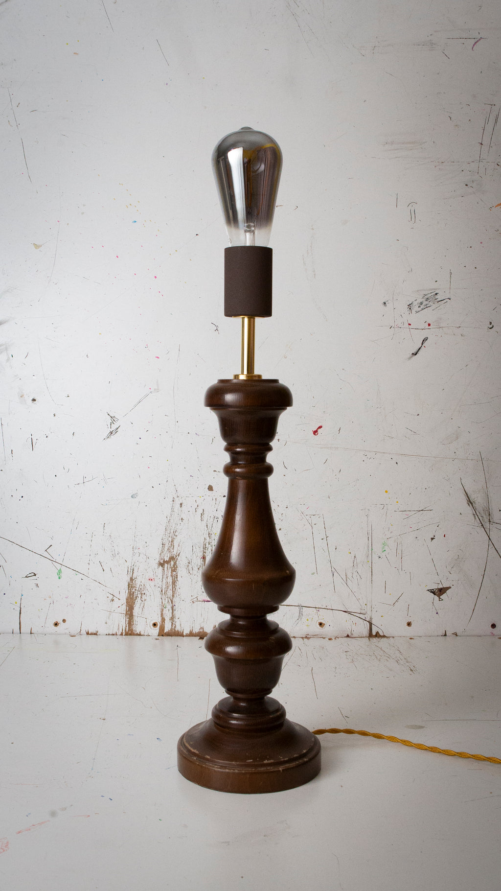 Vintage-style table lamp with wooden base and metallic shade on a white background